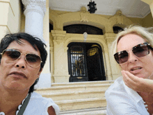 two women wearing sunglasses are posing for a picture in front of a building