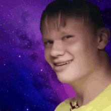 a young boy in a yellow shirt is smiling in front of a galaxy background