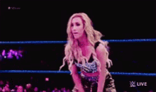 a woman in a wrestling ring with a live logo on the bottom