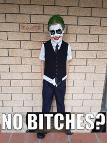 a boy dressed as the joker with the words no bitches behind him