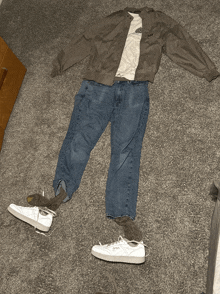 a person 's clothes are laid out on the floor including a jacket jeans and a t-shirt