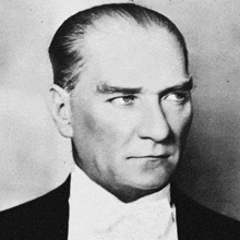 a black and white photo of a man in a suit and tie .