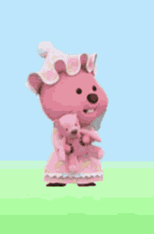 a pink teddy bear wearing a pink dress and hat is holding a small teddy bear .