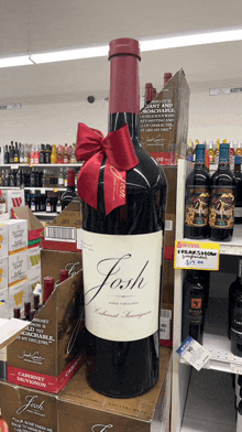 a large bottle of josh cabernet sauvignon is on display in a liquor store