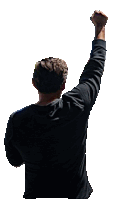 a man in a black shirt holds his fist up in the air