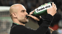 a man drinking from a green bottle with a label that says ' czeche slzy '