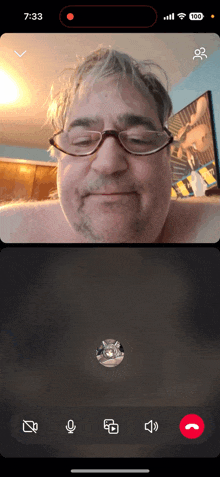 a man wearing glasses is talking on a video call