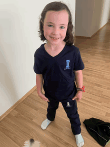 a little girl wearing a shirt with the letter i on the front