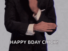 a man in a suit and tie is holding his sleeves up and says `` happy bday chic ! ''