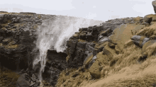 a waterfall is coming down a rocky cliff