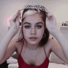 a woman is wearing a tiara on her head while sitting on a couch .