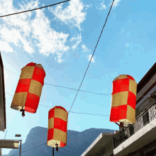 a row of red and yellow lanterns are hanging from a power line