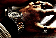 a man wearing a stainless steel watch with a skeleton face