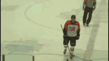 a hockey player in a jersey with the letter a on it is walking on the ice