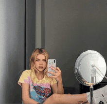 a woman is taking a selfie in front of a mirror with her phone