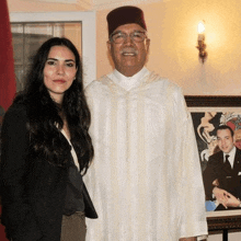 a man and a woman are posing for a picture in front of a picture of a man and woman .