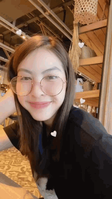 a woman wearing glasses and a black shirt smiles
