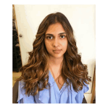 a woman in a blue shirt has long brown hair