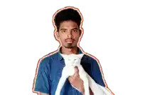 a man in a blue shirt is holding a white cat in his arms