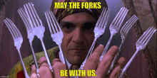 a man is holding a bunch of forks in his hands with the words may the forks be with us