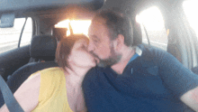 a man and woman kissing in a car with the sun shining through the window