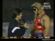 a man is talking to a wrestler with the word gladiators on the bottom