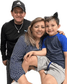 a man wearing an adidas hat is standing next to a woman and a child