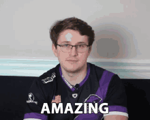 a man with glasses and a purple shirt that says amazing on it