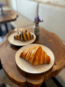 a croissant on a plate next to a chocolate croissant