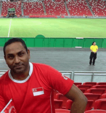 a man wearing a red shirt with a singapore flag on the sleeve