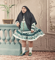 a woman in a green and white dress leaning on a railing