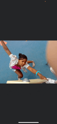 a young girl is stretching her legs on a blue floor