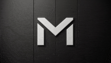 a white letter m on a black wall