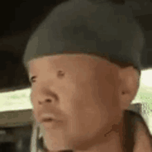 a man wearing a beanie is sitting in a car .