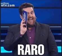 a man in a suit is holding a piece of paper with the word raro on it