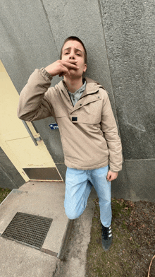 a young man smoking a cigarette in front of a building with a sign that says ' exit '