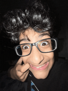 a young boy wearing glasses is making a face