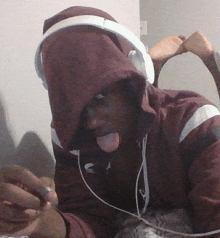 a man wearing headphones and a maroon hoodie with the letter s on it