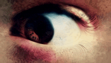 a close up of a person 's eye with a reflection of roman numerals in it