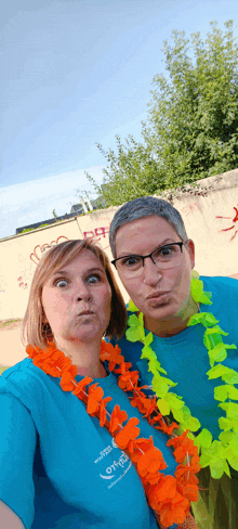 two women are posing for a picture with one wearing a blue shirt that says ' love ' on it