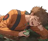 a boy is laying on the ground holding a frog in his hand