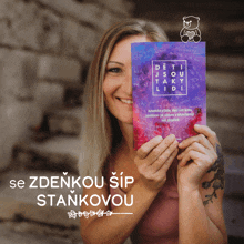 a woman is holding a book that says deti jsou taky lidi