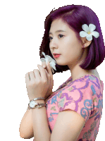 a woman with purple hair has a flower in her hair and a watch on her wrist