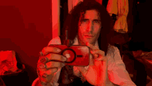 a man is taking a picture of himself with a red iphone