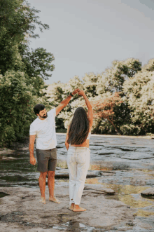 a man and a woman are dancing in the water