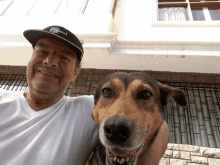 a man wearing a peru hat is holding a brown dog