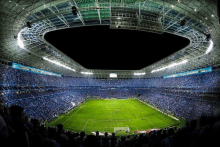 a soccer stadium filled with people and a scoreboard that says pepsi on it