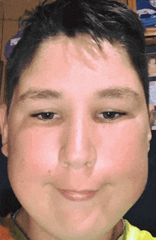 a close up of a young boy 's face with a yellow shirt