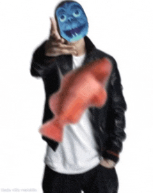 a man with a blue mask on his face is holding a red fish .