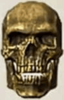 a close up of a gold skull with teeth on a white surface .